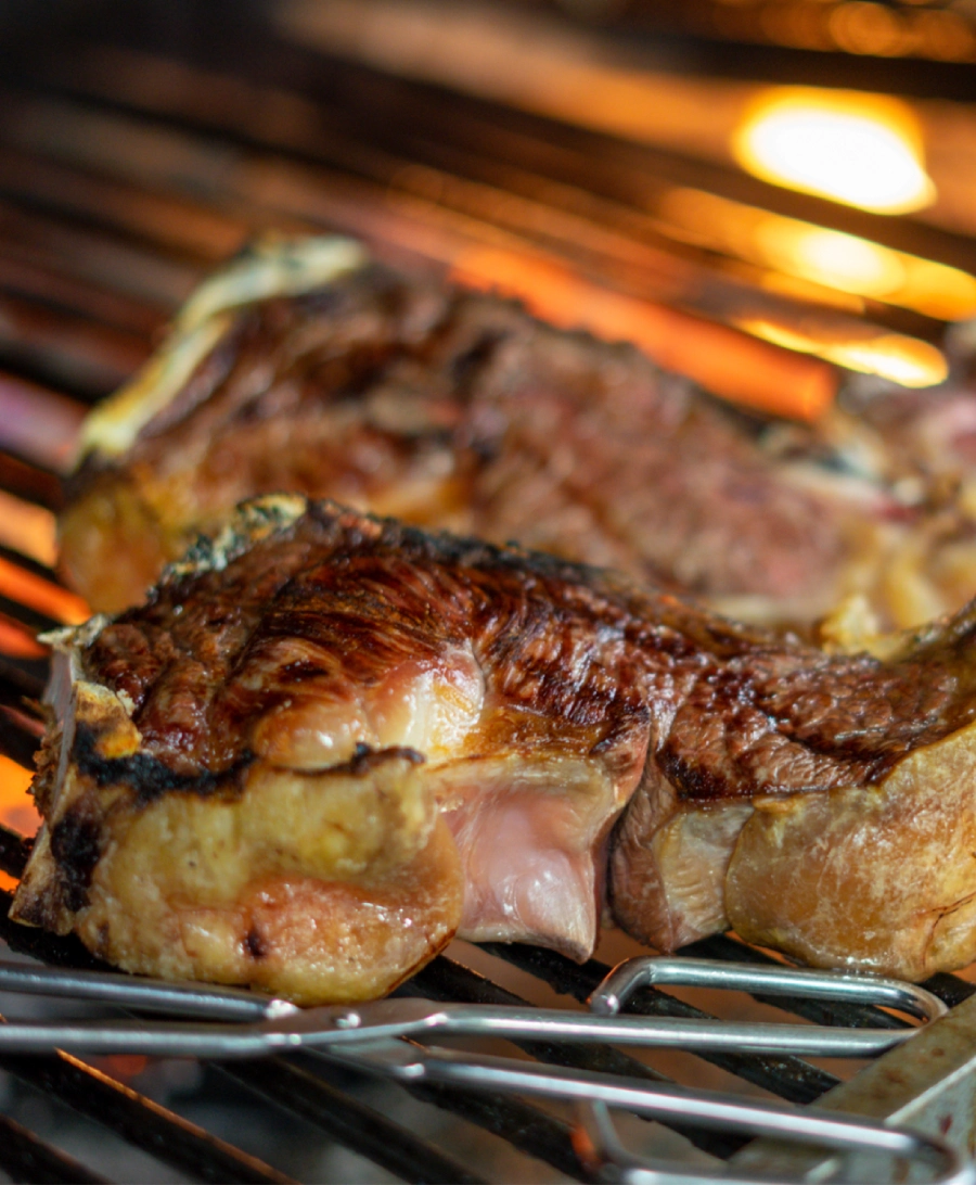 chuletones sobre una parrilla al fuego